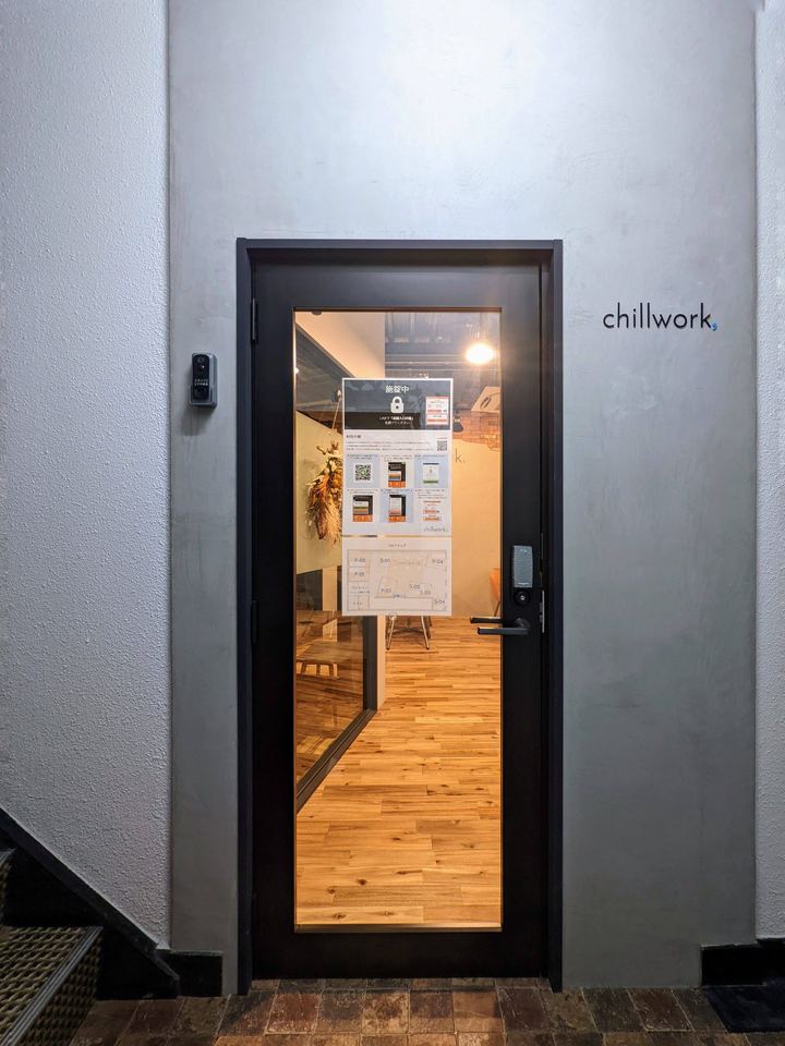 2階の入口。閉まったガラス扉と、右の壁にchillworkのロゴ